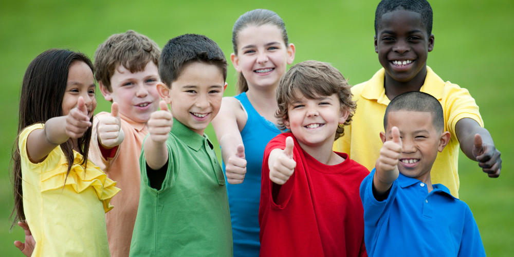 group of children giving thumbs up
